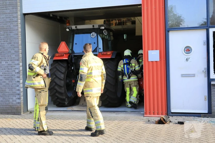 Medewerkers blussen brand in bedrijfsverzamelgebouw