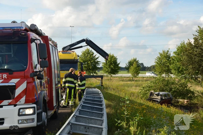 Auto belandt naast de snelweg en vliegt in brand