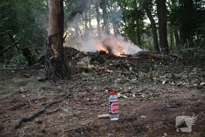 Berg afval in bos in brand gestoken