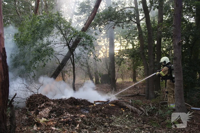 Berg afval in bos in brand gestoken