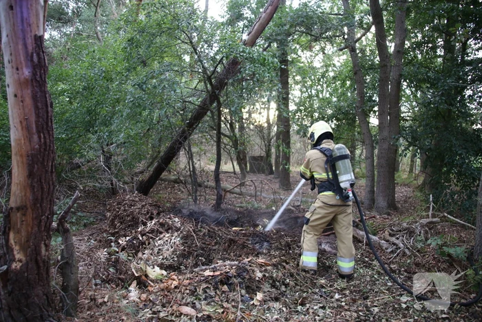 Berg afval in bos in brand gestoken