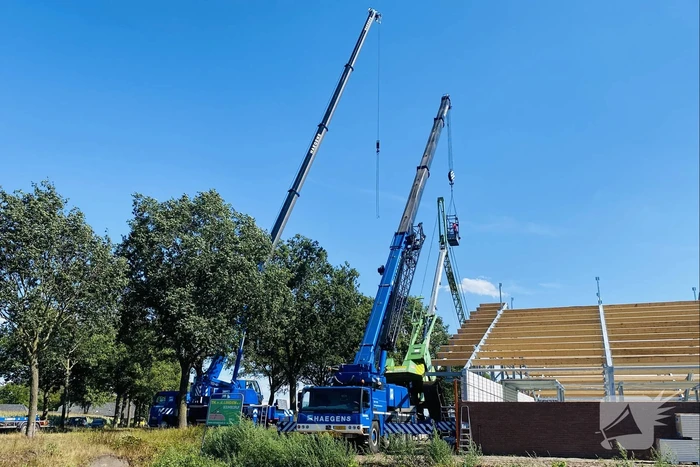 Bouwkraan achter stal omgevallen