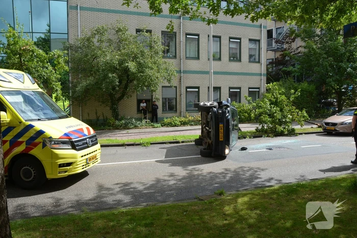 Auto vliegt uit de bocht en belandt op zijn kant