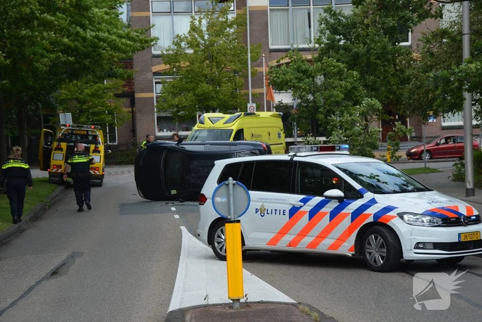 Auto vliegt uit de bocht en belandt op zijn kant