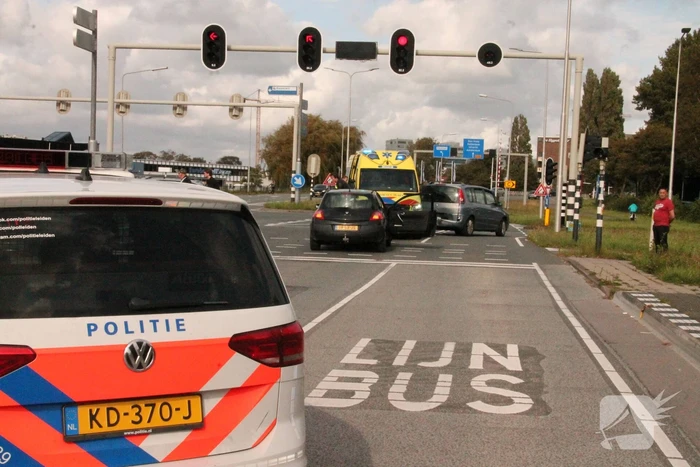Twee auto's botsen op elkaar voor stoplicht