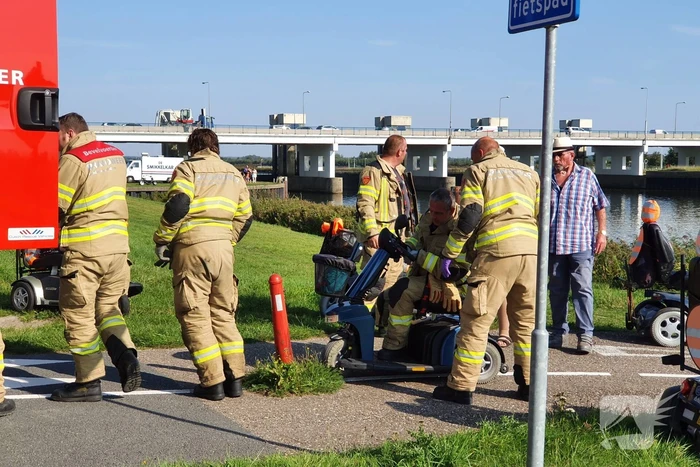Vrouw rijdt met scootmobiel op verkeerspaal