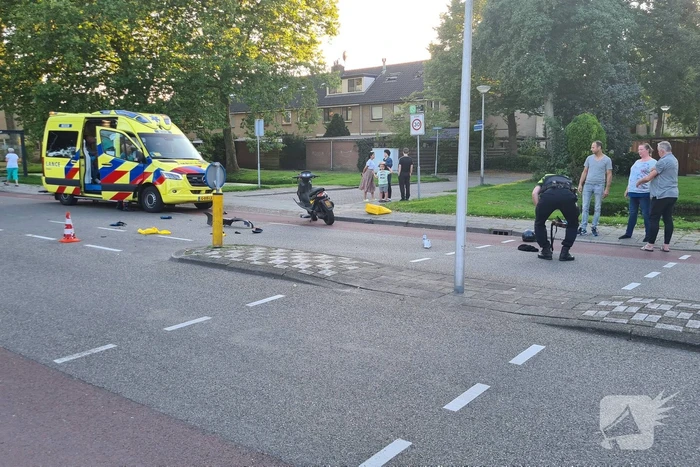 Taxi en scooter botsen op kruising