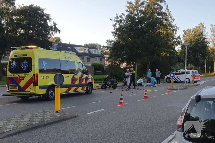 Taxi en scooter botsen op kruising