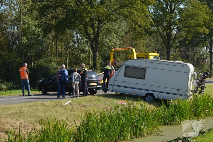 Auto met caravan raakt van de weg