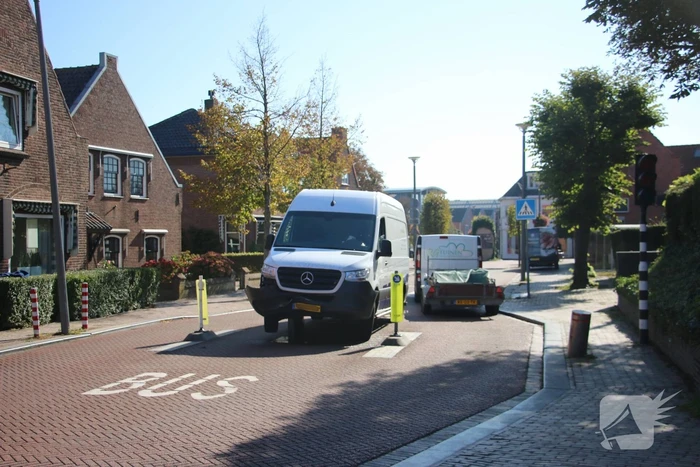 Bestelbus komt vast te zitten op paal van bussluis