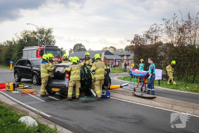 Vrouw bekneld in voertuig bij aanrijding op kruising