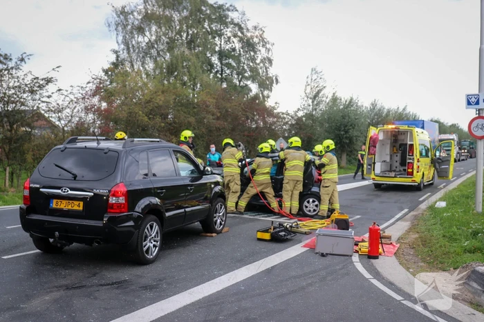 Vrouw bekneld in voertuig bij aanrijding op kruising