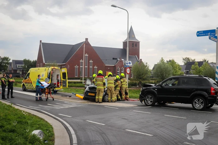 Vrouw bekneld in voertuig bij aanrijding op kruising