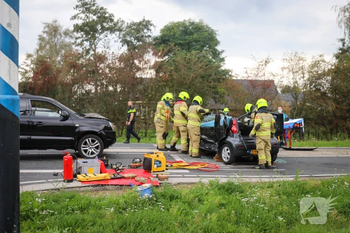 Vrouw bekneld in voertuig bij aanrijding op kruising