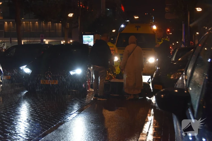 Scooterrijder valt met scooter tegen auto