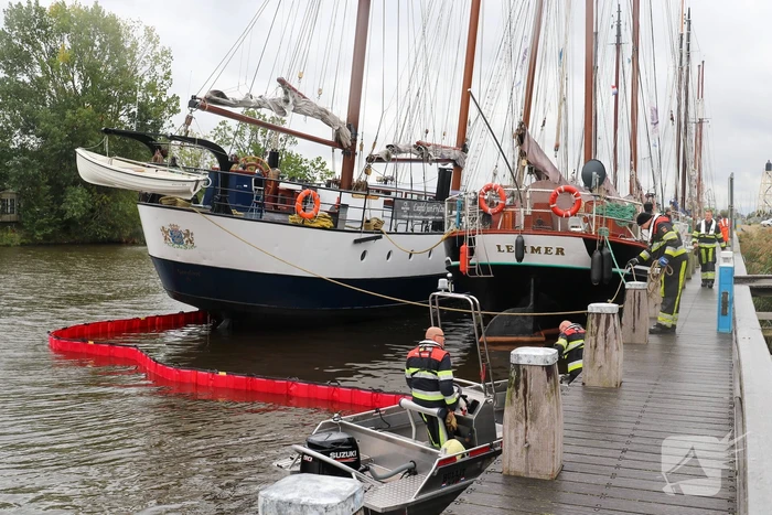Brandweer plaats olieschermen voor lekkend zeilschip