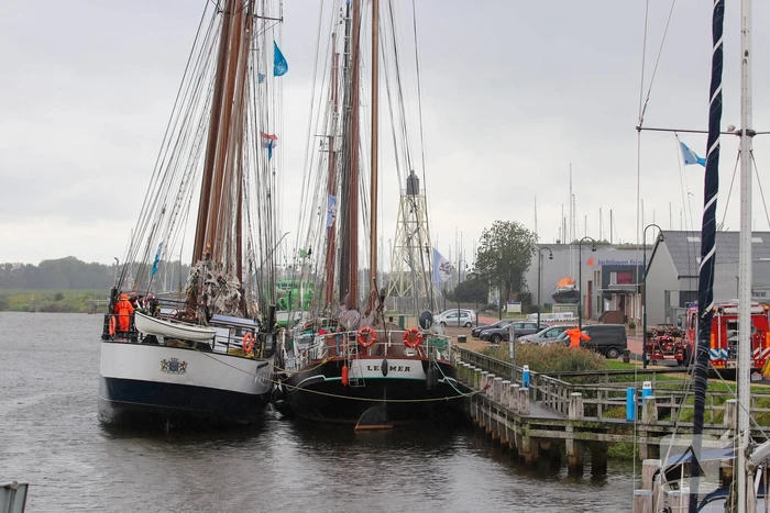 Brandweer plaats olieschermen voor lekkend zeilschip