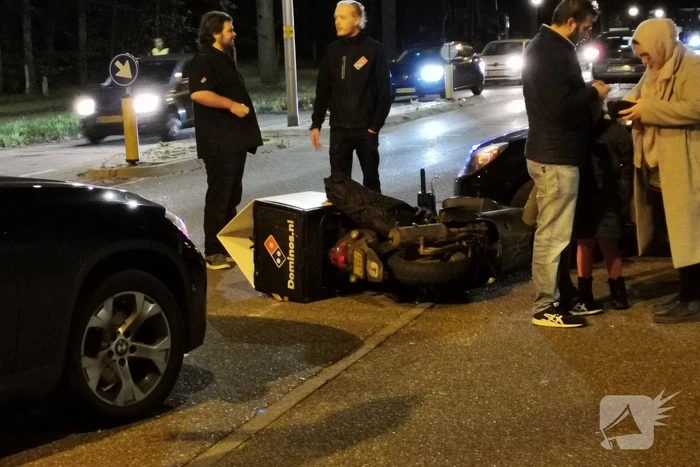 Maaltijdbezorger botst op kruising met auto