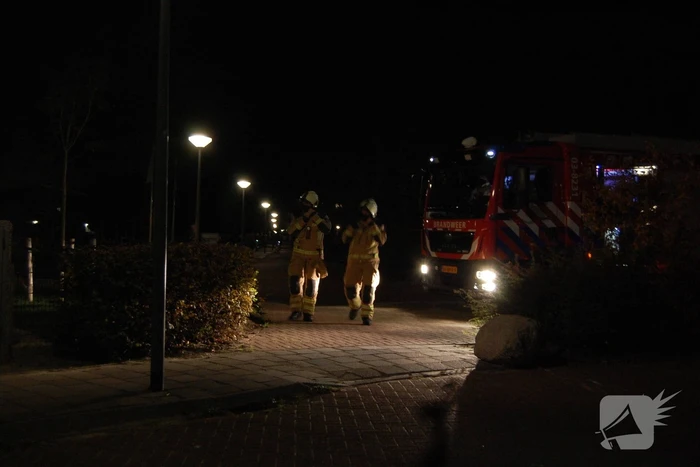 Brandweer blust brandende papiercontainer