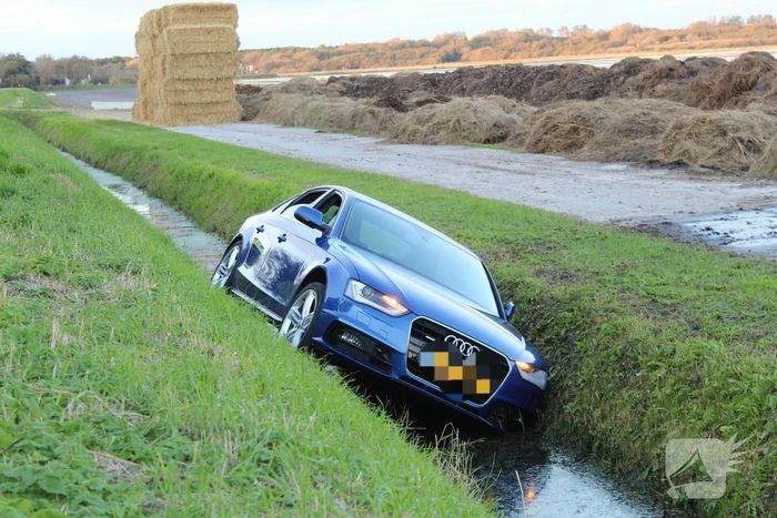 Personenauto raakt steen en rijdt het water in
