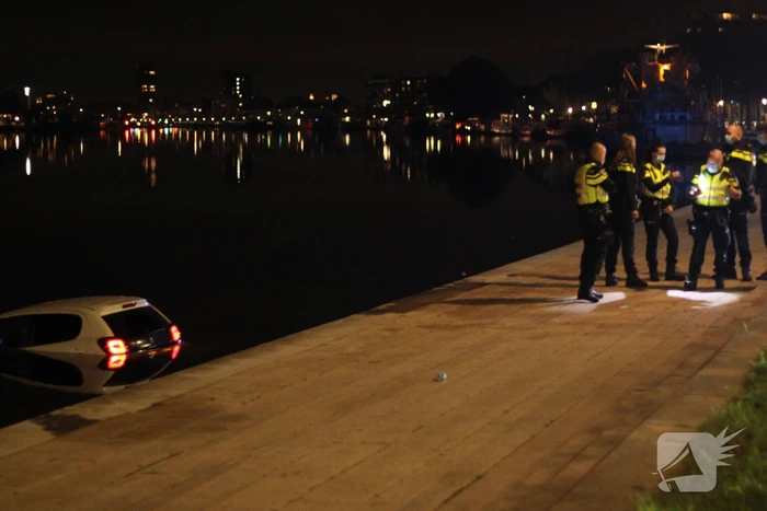 Personenauto rijdt het Spaarne in