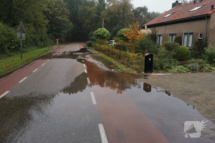 Straat onder water door gesprongen waterleiding