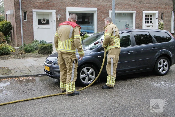 Brandweer blust brand in motorkap