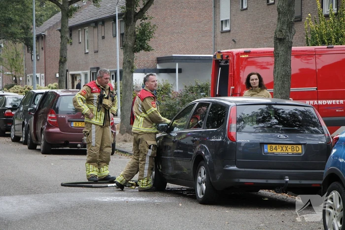 Brandweer blust brand in motorkap