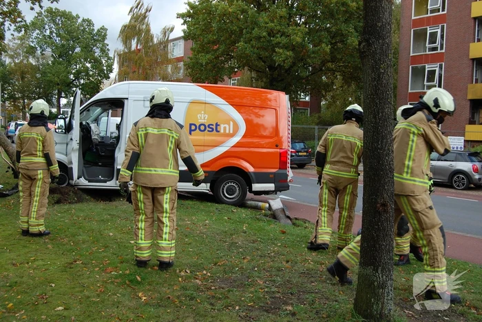 Bestelbus Postnl belandt met hoge snelheid tegen boom