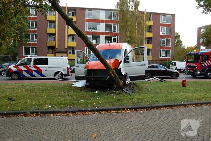 Bestelbus Postnl belandt met hoge snelheid tegen boom