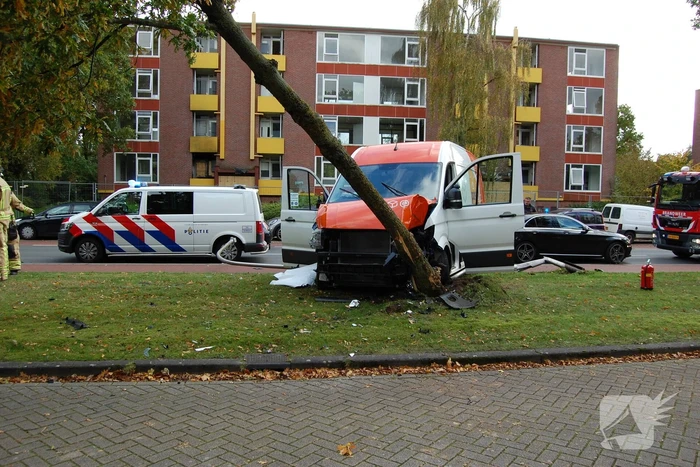 Bestelbus Postnl belandt met hoge snelheid tegen boom