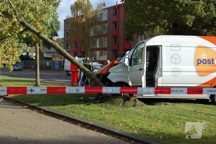 Bestelbus Postnl belandt met hoge snelheid tegen boom
