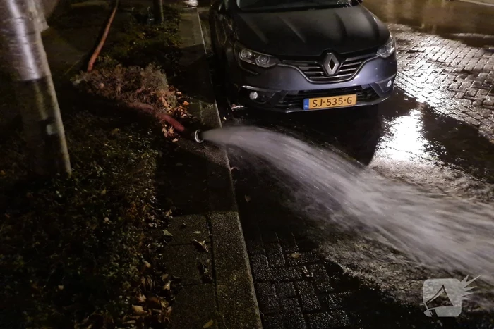 Straat onderwater door gesprongen hoofdwaterleiding