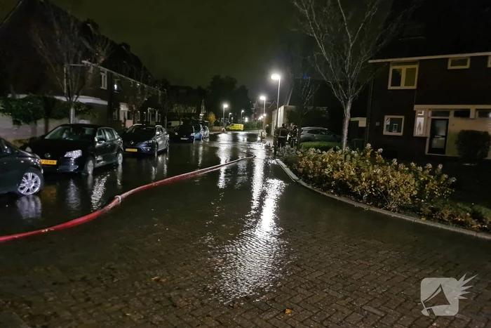 Straat onderwater door gesprongen hoofdwaterleiding