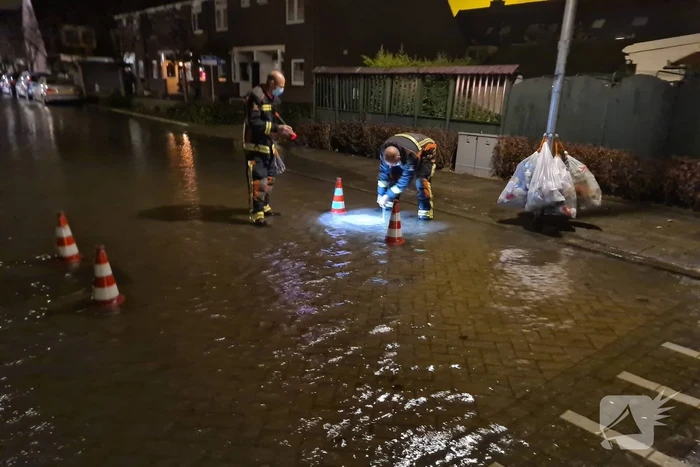 Straat onderwater door gesprongen hoofdwaterleiding