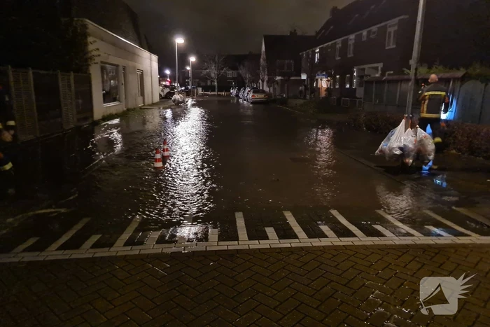 Straat onderwater door gesprongen hoofdwaterleiding