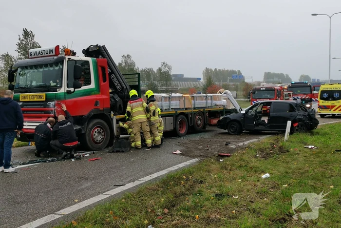 Auto van afrit geschoten, botst frontaal op vrachtwagen