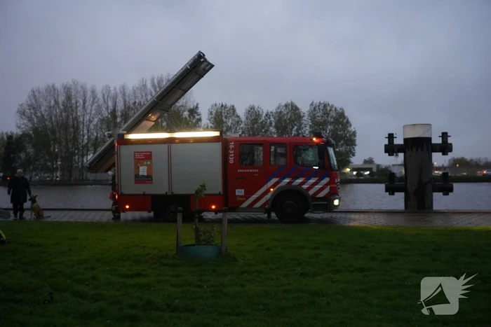 Brandweer blust brand in boom met emmer