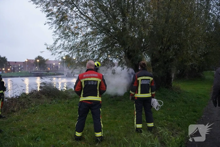 Brandweer blust brand in boom met emmer