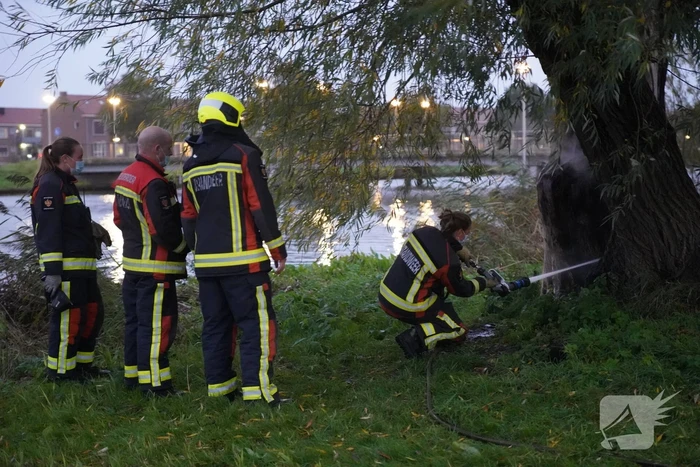 Brandweer blust brand in boom met emmer