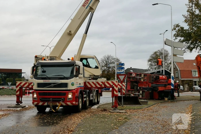 Grote aanhanger met verreiker op z'n kant op rotonde