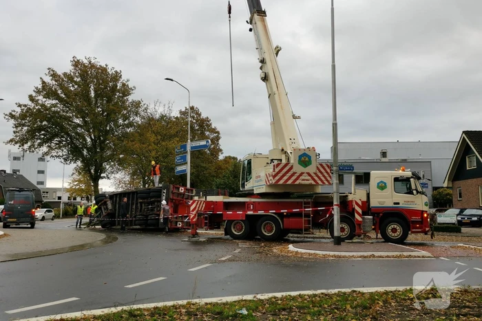 Grote aanhanger met verreiker op z'n kant op rotonde