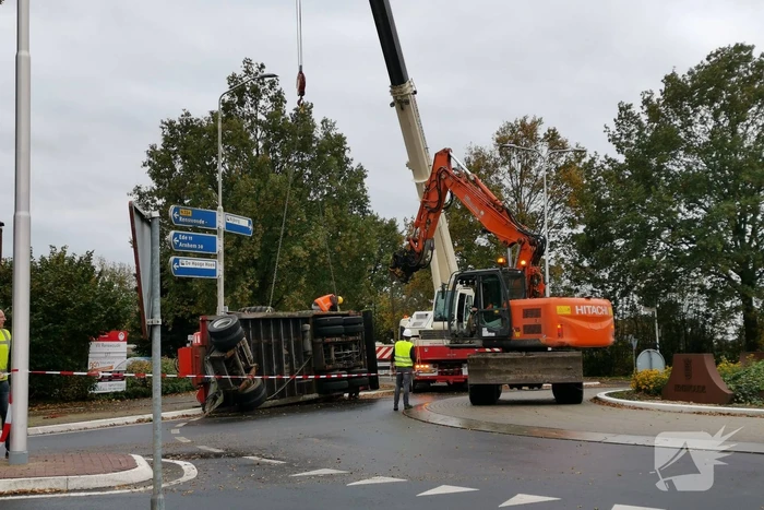 Grote aanhanger met verreiker op z'n kant op rotonde
