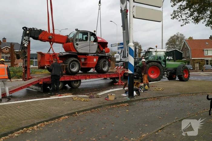 Grote aanhanger met verreiker op z'n kant op rotonde