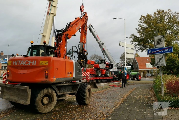 Grote aanhanger met verreiker op z'n kant op rotonde