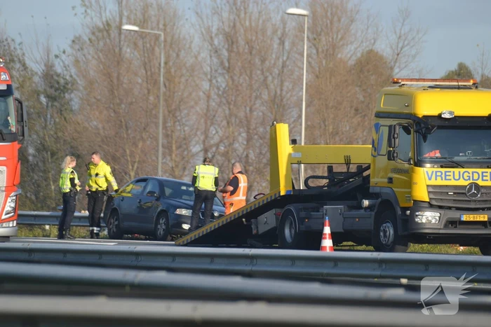 Personenauto heeft schade na botsing tegen vangrail