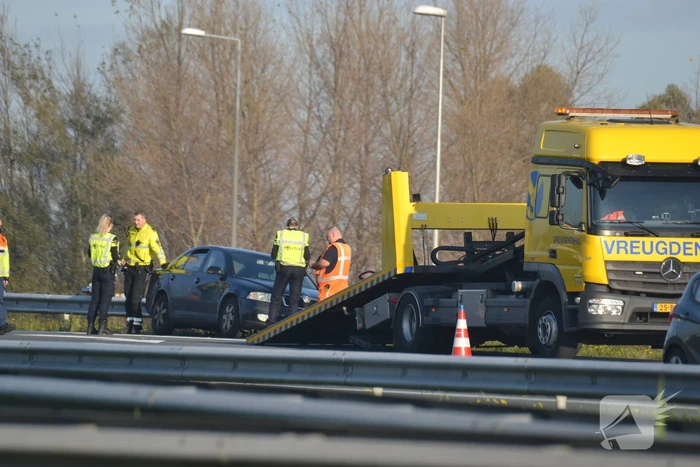 Personenauto heeft schade na botsing tegen vangrail