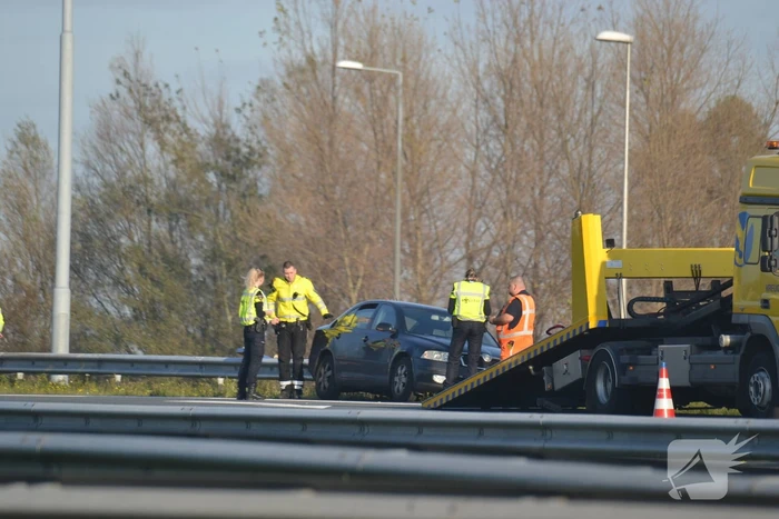 Personenauto heeft schade na botsing tegen vangrail