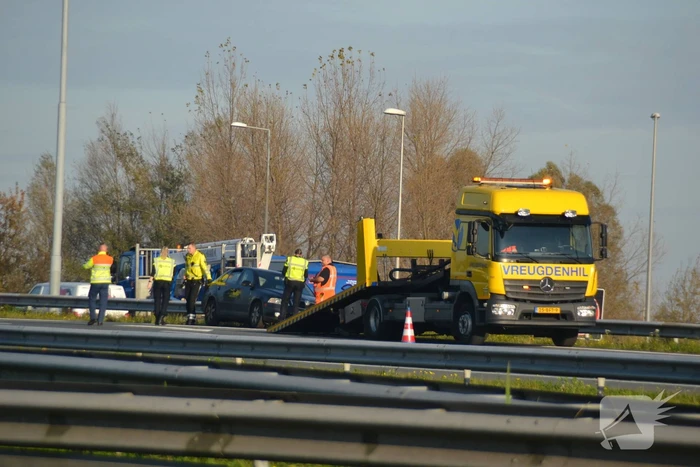 Personenauto heeft schade na botsing tegen vangrail
