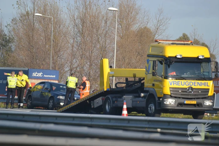 Personenauto heeft schade na botsing tegen vangrail